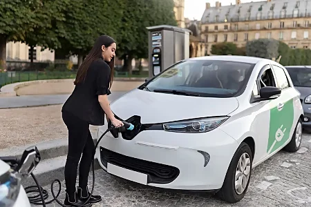 femme rechargeant sa voiture électrique à la borne