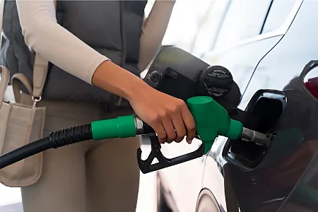femme mettant de l'essence dans sa voiture thermique