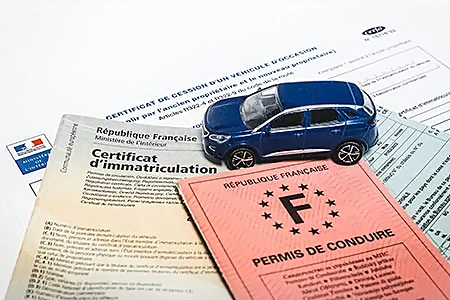 jouet petite voiture posée sur certificat d'immatriculation et permis de conduite et certificat de c